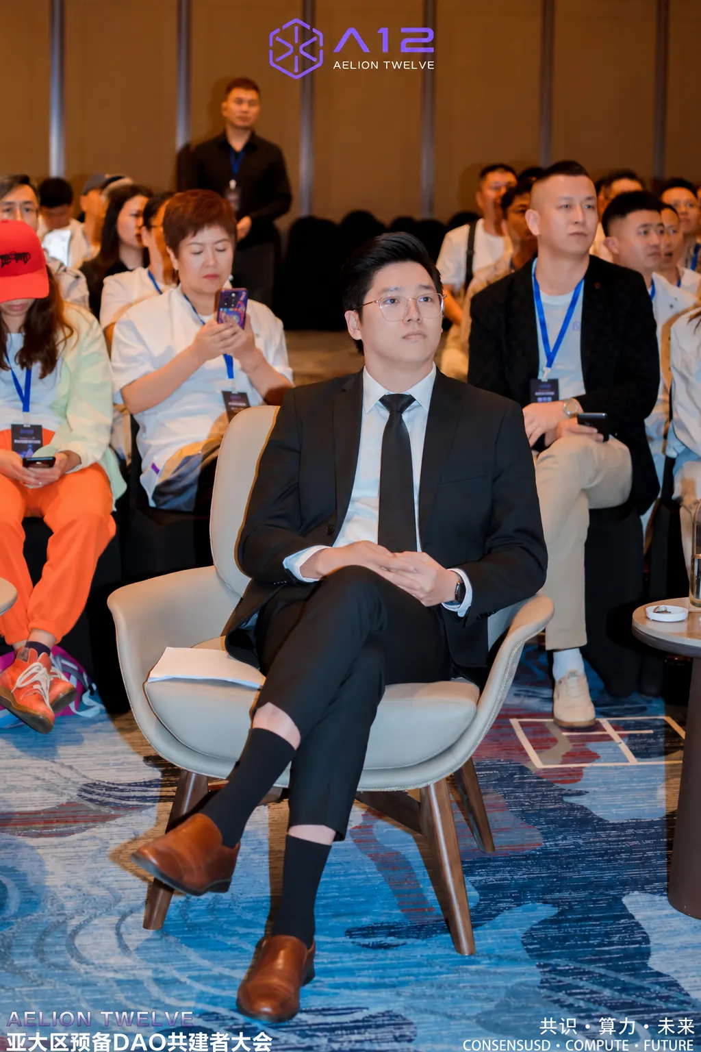 Dr. Jovian Tan seated in the front row of a conference audience